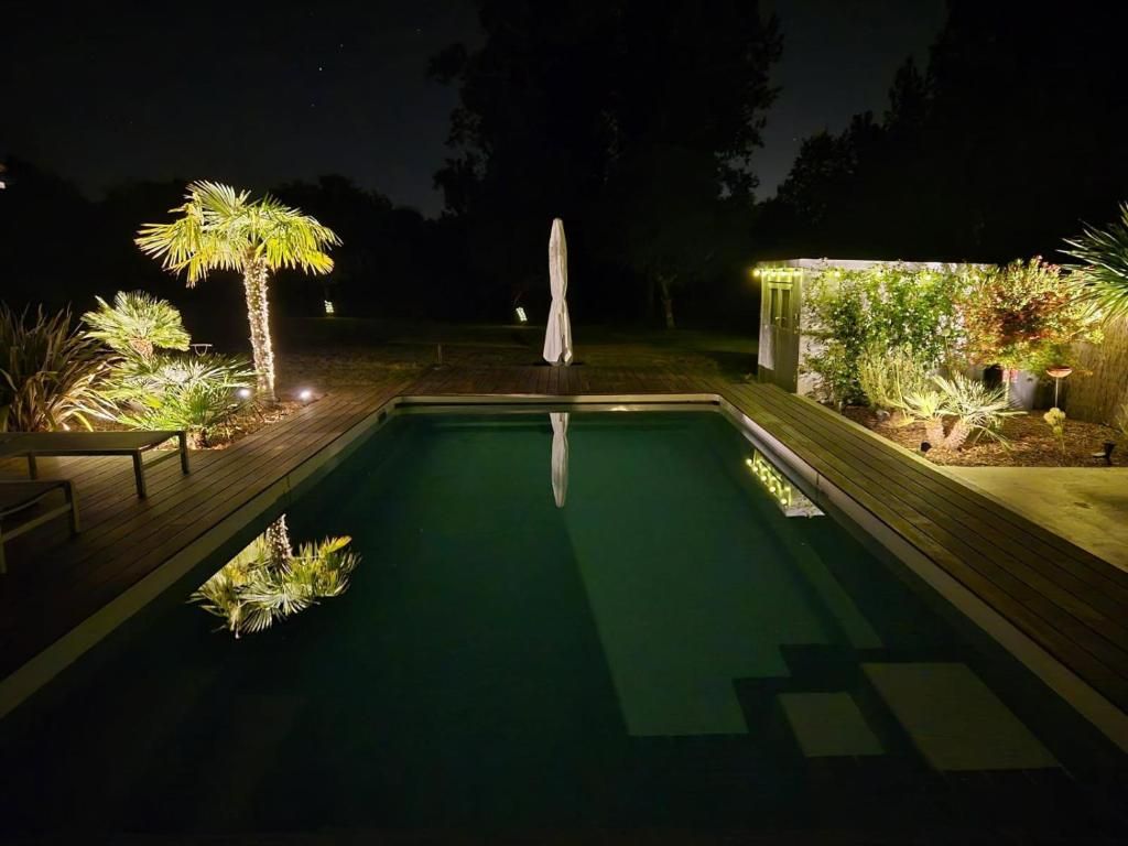 Vue nocturne de la piscine et de la pergola Vue nocturne de la piscine et de la pergola