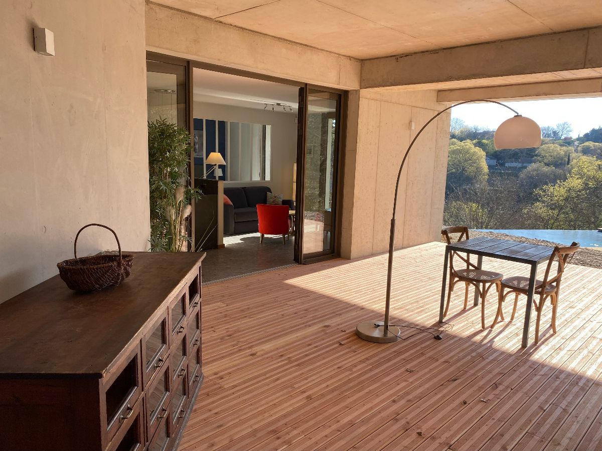 Une grande terrasse couverte, face à la piscine et donnnant directement sur le séjour-cuisine