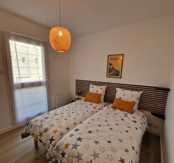 une chambre avec 2 lits simples qui se transforment en lit double avec un surmatelas